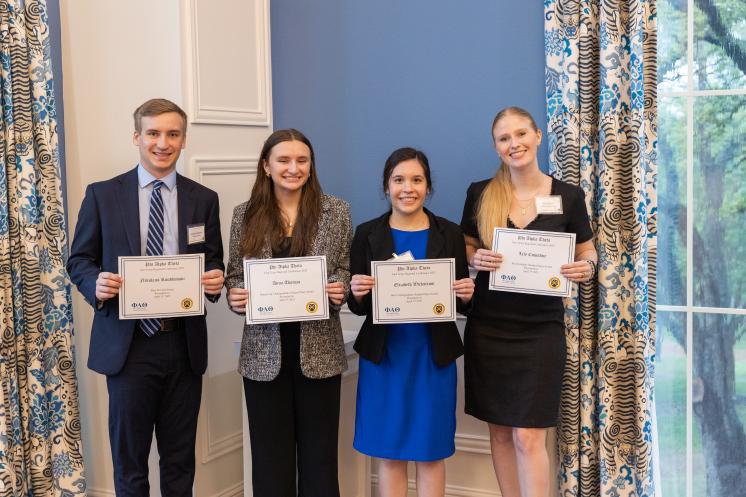 A group of people standing holding certificates in formal attire