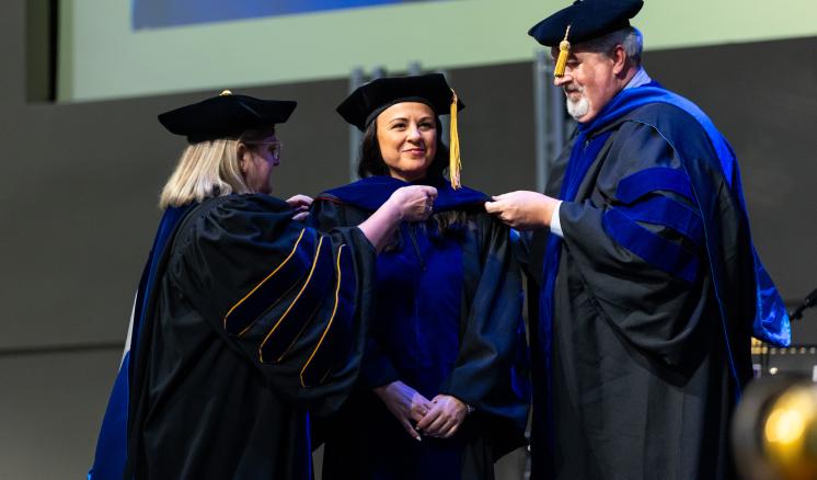 A group of people standing on a stage in academic regalia