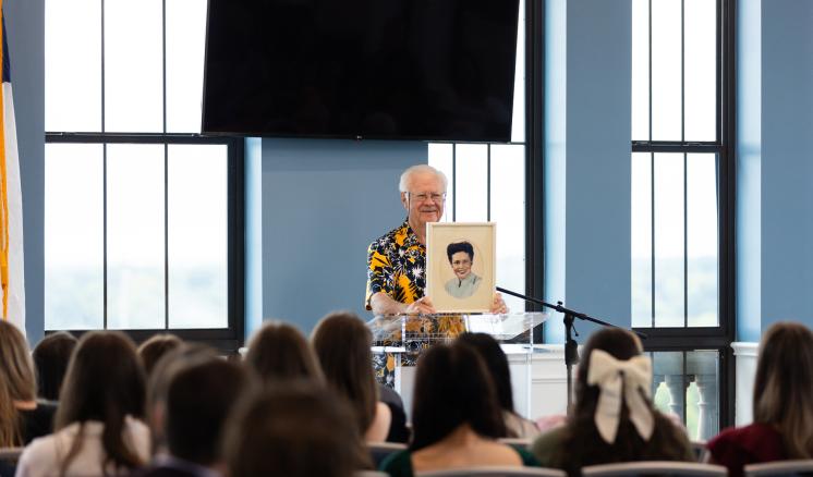 A man stood at a podium addressing a crowd of people