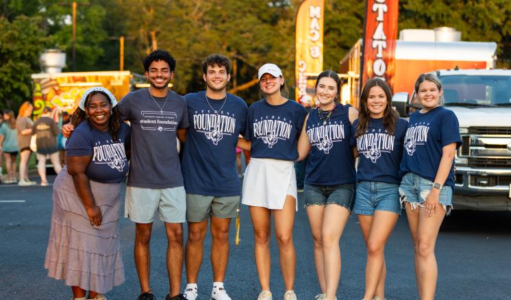 A group of college students standing together outside with ETBU Student Foundation written on their shirts