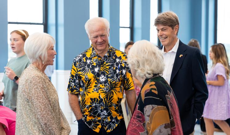 Men and women standing in a group together smiling in a circle