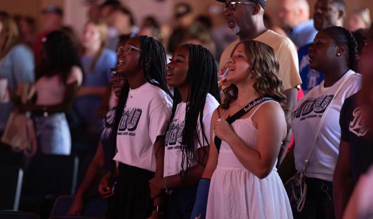 A crowd of people inside looking up and smiling together