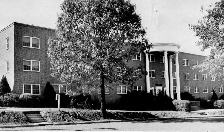 Historical black and white photo of the front of Feagin Hall at East Texas Baptist University, a red brick building with white columns.