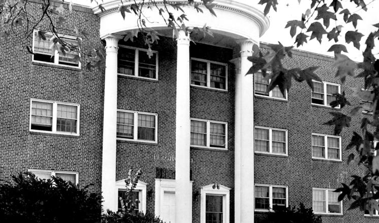 Historical black and white photo of the front of Feagin Hall at East Texas Baptist University, a red brick building with white columns.