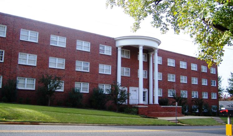 Historical color photo of the front of Feagin Hall at East Texas Baptist University, a red brick building with white columns.