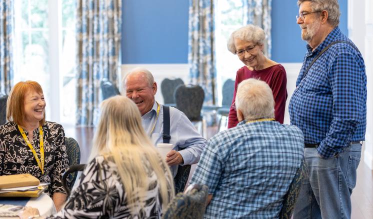 a group of older people smiling and talking