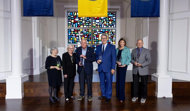 a group of people standing in formal attire on a stage