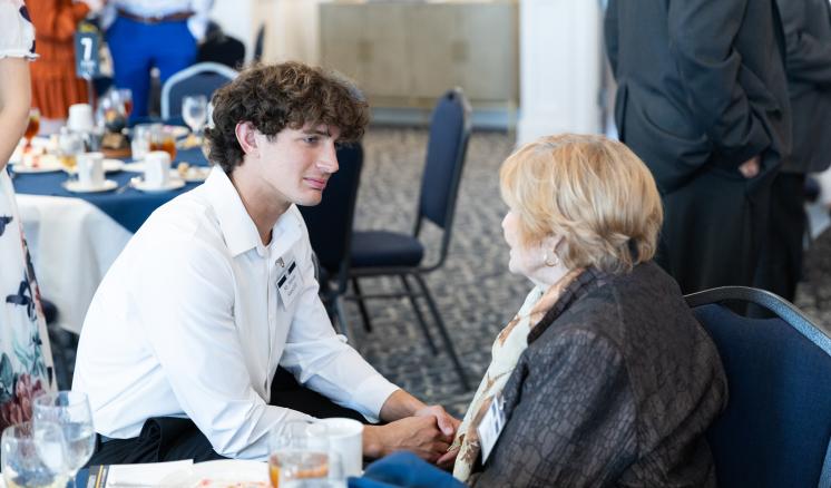 A man and woman sat together talking at a table