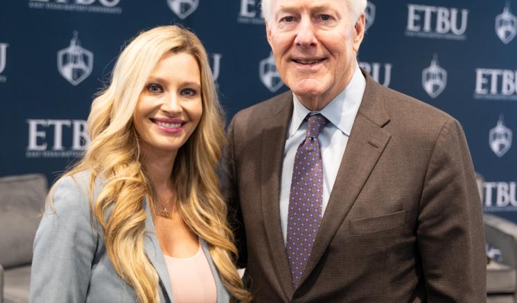 A man and woman standing together smiling in professional attire