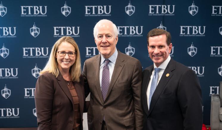 3 people standing in front of an ETBU backdrop smiling