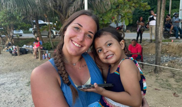 A woman holding a small child smiling