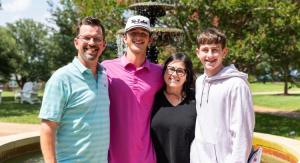 a group of people standing outside together smiling in front of a fountain
